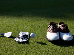 golf balls, clubs, and shoes on course